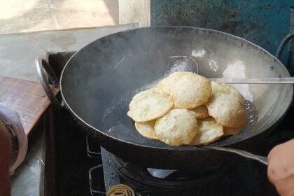 Deep frying Puri in Kolkata, India Galletas fritas de trigo (Pūrī)