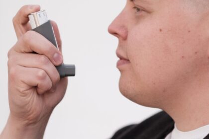 Persona usando un inhalador como imagen educativa para artículo sobre asma, sibilancias y Ayurveda