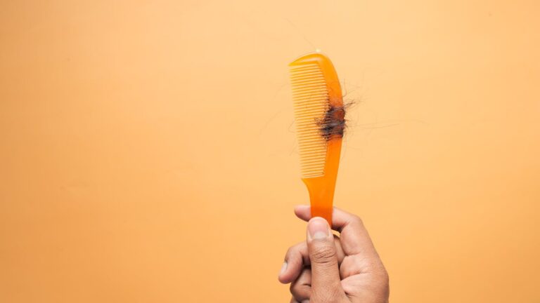 Cabello caído sobre un peine como imagen educativa para artículo sobre calvicie y Ayurveda