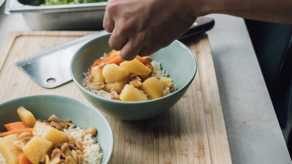 Preparación de bowls con arroz, vegetales cocidos y hierbas para dieta Vata Pitta