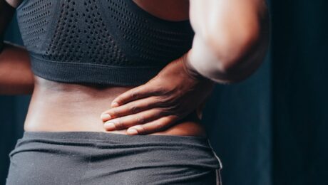 Dolor de espalda desde Ayurveda – imagen destacada Persona sosteniendo la zona lumbar con dolor de espalda como imagen educativa para artículo sobre Ayurveda