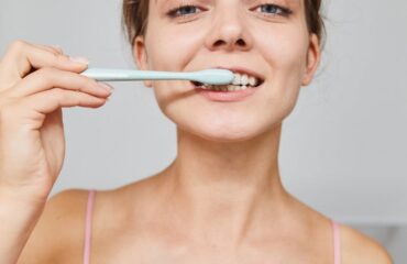 Mal aliento desde Ayurveda – imagen destacada Mujer cepillándose los dientes como imagen educativa para artículo sobre mal aliento y Ayurveda