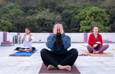 Grupo practicando meditación y respiración consciente al aire libre en India