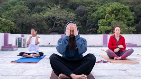 Grupo practicando meditación y respiración consciente al aire libre en India